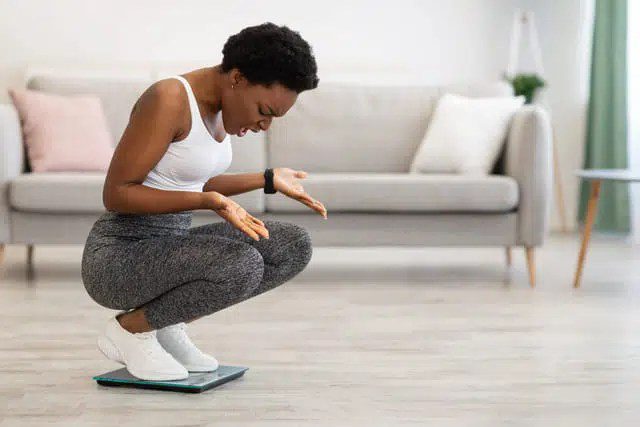 Woman Kneeling on a Scale and Looking Angry