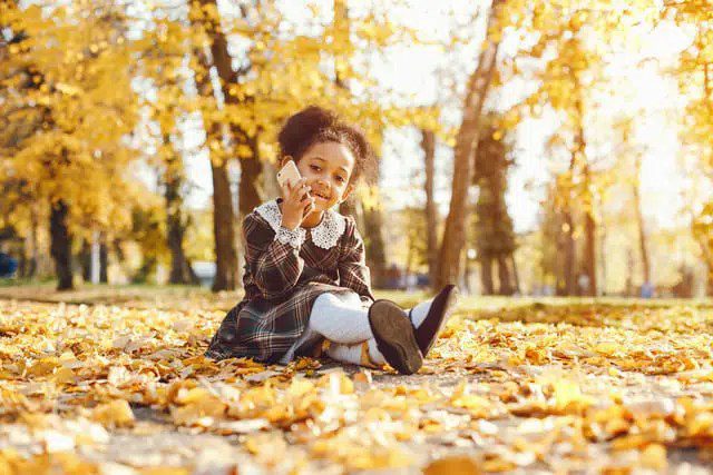 Young Girl Outdoors in the Woods Smiling and Talking on a Cellphone